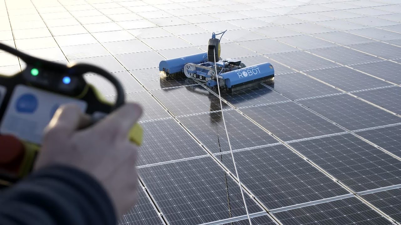 Solar panel cleaning by technician on roof top